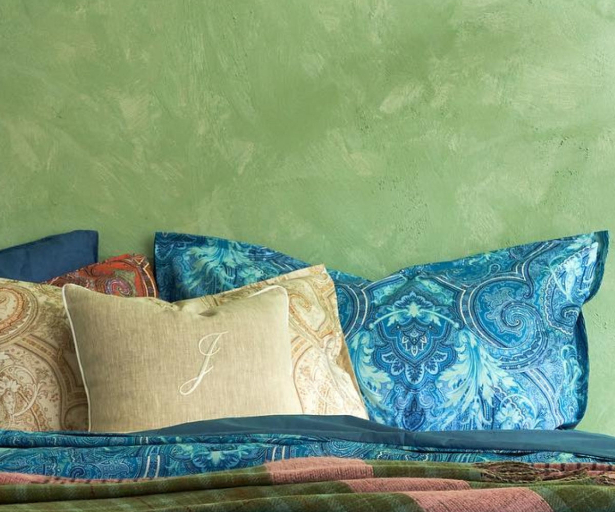 Muro verde con guanciali letto con federe con fantasia di colore celeste e corda
