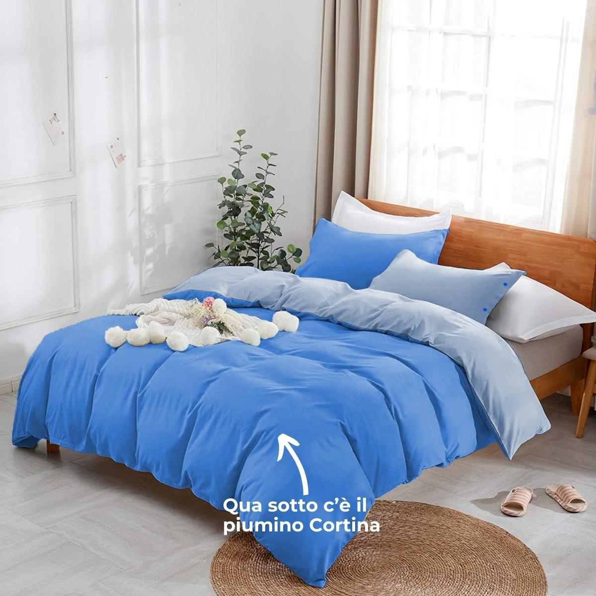 Parure copripiumino blu su letto matrimoniale